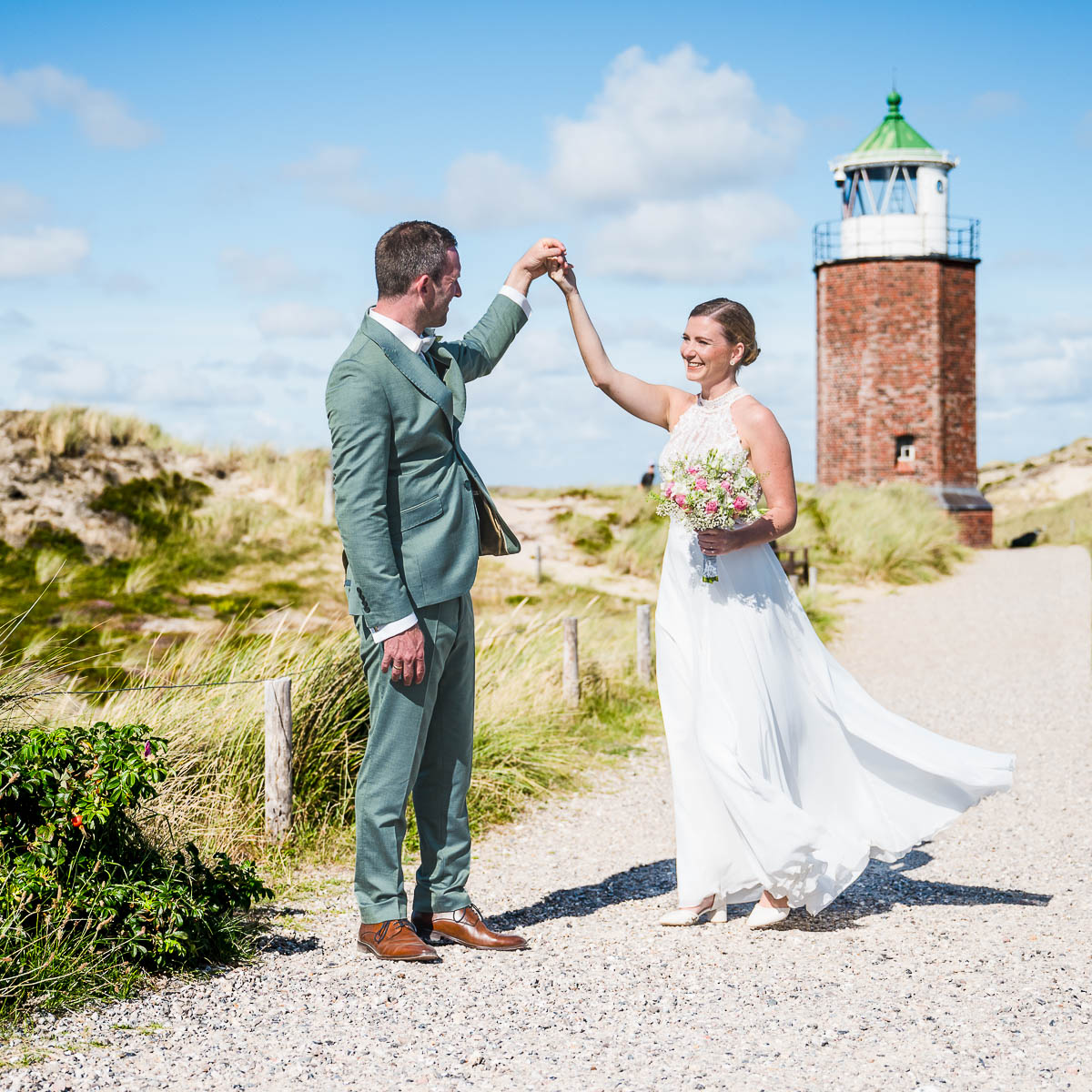 Hochzeitsfotograf Sylt Brautpaarportrait am Strand in Kampen mit Leuchtturm von Jochen Nölle